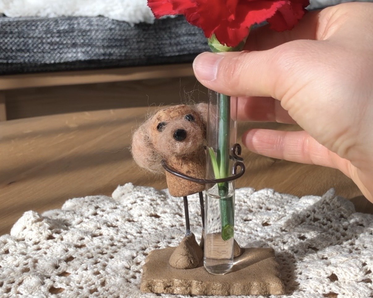 複数のコルク人形と花を飾った一輪挿し